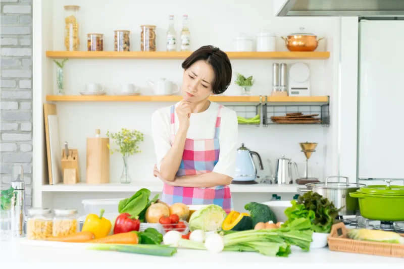 キッチンで野菜を悩む女性